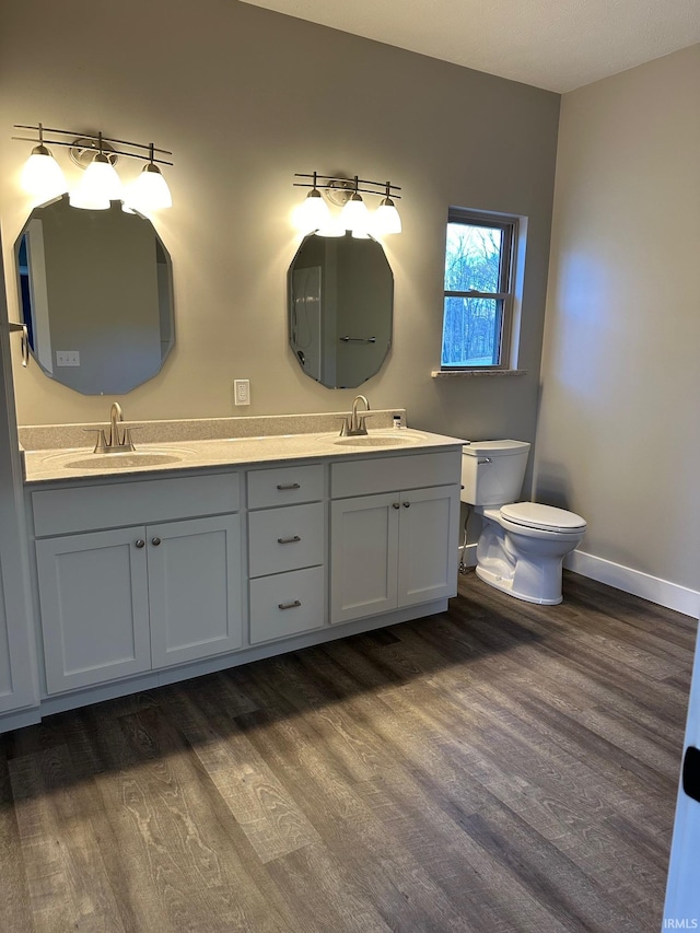 bathroom featuring toilet, vanity, and hardwood / wood-style flooring