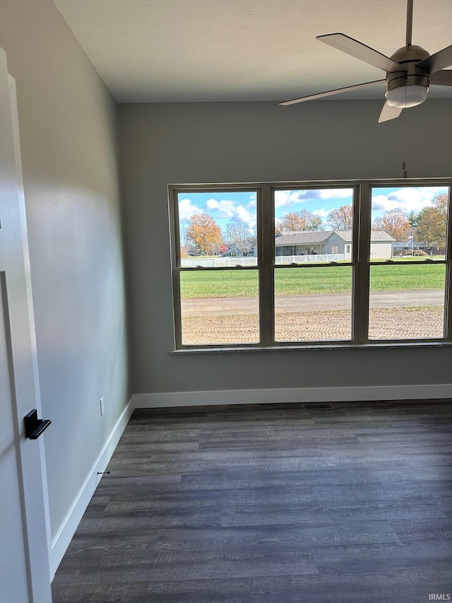 unfurnished room with ceiling fan, dark hardwood / wood-style flooring, and a healthy amount of sunlight