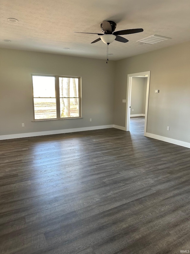 empty room featuring a textured ceiling and dark hardwood / wood-style floors