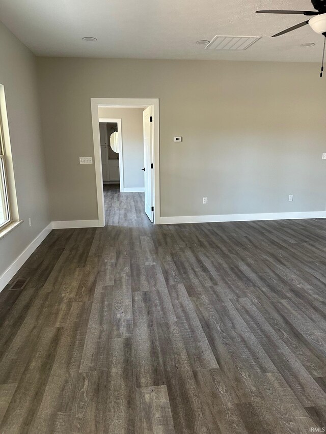 empty room with ceiling fan and dark hardwood / wood-style flooring