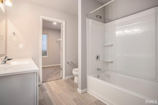 full bathroom with wood-type flooring, toilet, shower / bathing tub combination, and vanity