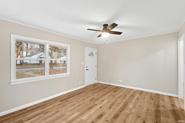 unfurnished room featuring a textured ceiling, light wood-type flooring, ceiling fan, and ornamental molding