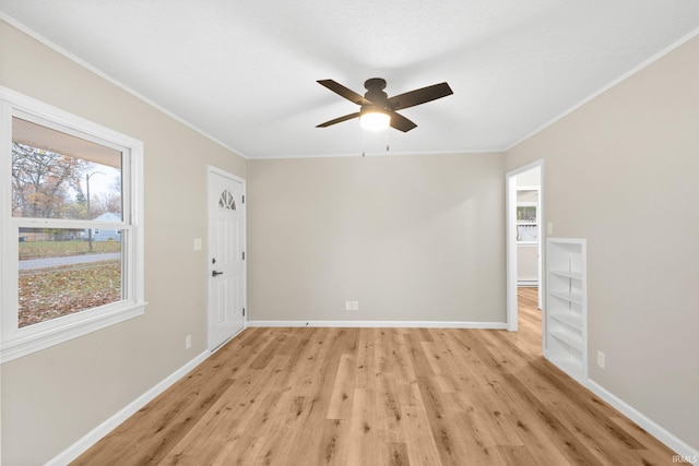 empty room featuring light wood-type flooring, ceiling fan, and ornamental molding