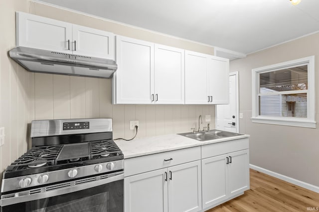 kitchen with stainless steel range with gas cooktop, sink, and white cabinets