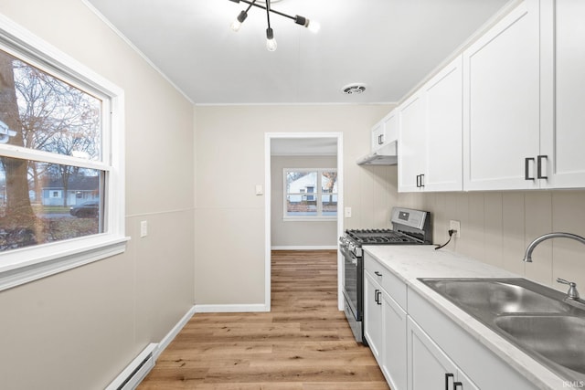 kitchen with ornamental molding, gas range, sink, light hardwood / wood-style flooring, and white cabinetry