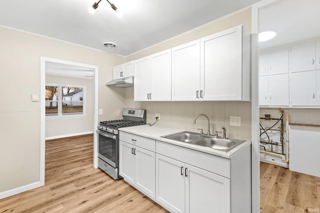 kitchen with white cabinets, gas stove, light hardwood / wood-style floors, and sink