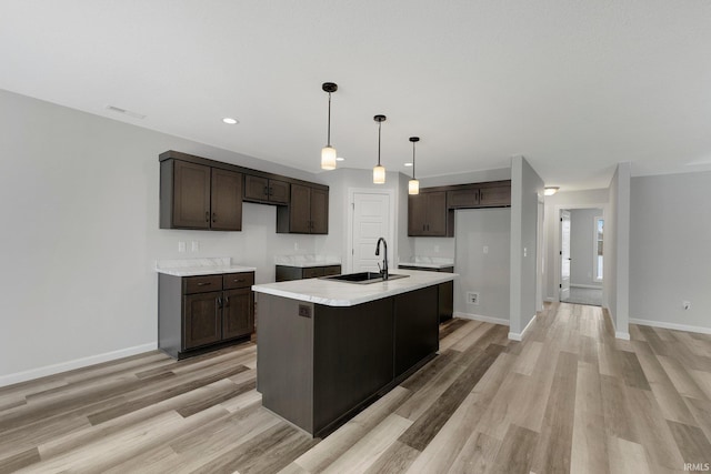 15384 Brimwillow Dr, Huntertown, IN 46748 - kitchen with a sink, dark brown cabinetry, light wood-style flooring, light countertops, and recessed lighting