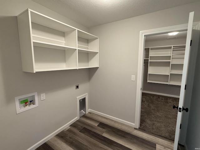 clothes washing area with hookup for a washing machine, a textured ceiling, dark hardwood / wood-style floors, and electric dryer hookup