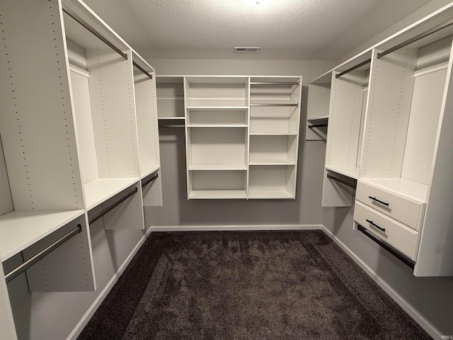 walk in closet featuring dark colored carpet