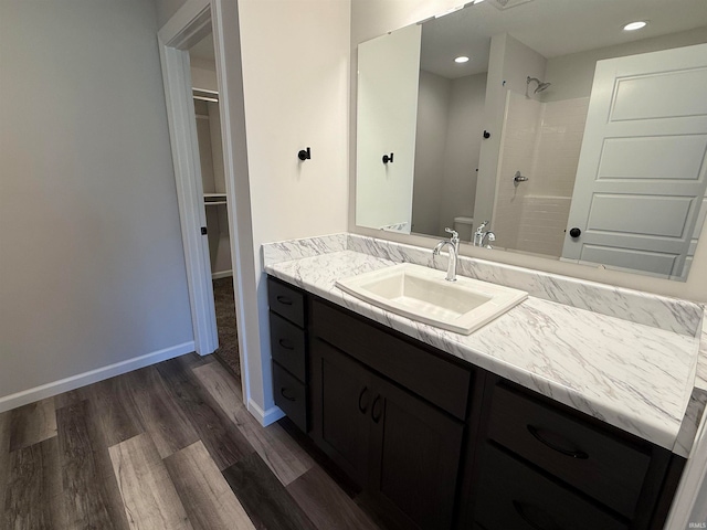 bathroom with walk in shower, toilet, vanity, and hardwood / wood-style flooring