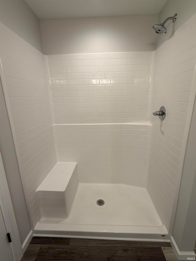 bathroom featuring wood-type flooring and tiled shower