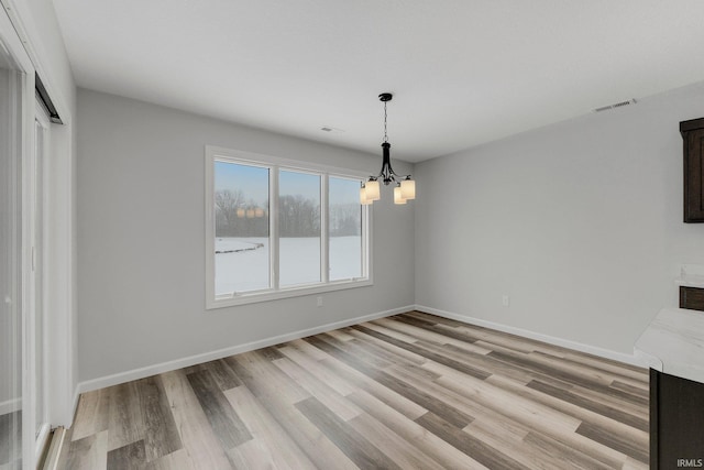 15384 Brimwillow Dr, Huntertown, IN 46748 - unfurnished dining area featuring light wood-style floors, a chandelier, and baseboards