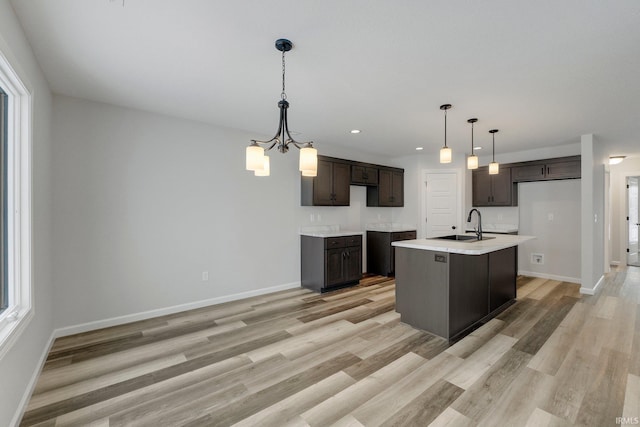 15384 Brimwillow Dr, Huntertown, IN 46748 - kitchen featuring a sink, dark brown cabinets, light wood-type flooring, baseboards, and light countertops