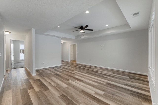 15384 Brimwillow Dr, Huntertown, IN 46748 - unfurnished living room with a raised ceiling, baseboards, ceiling fan, light wood-type flooring, and recessed lighting