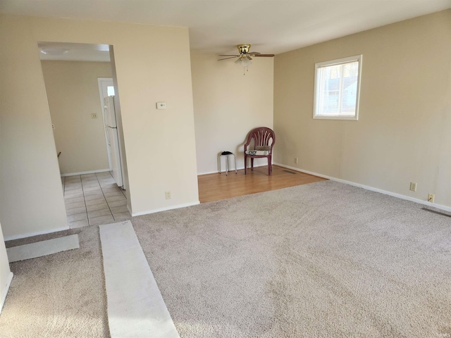 carpeted spare room featuring ceiling fan