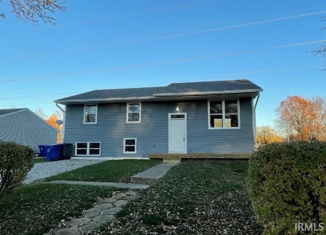 rear view of house featuring a yard