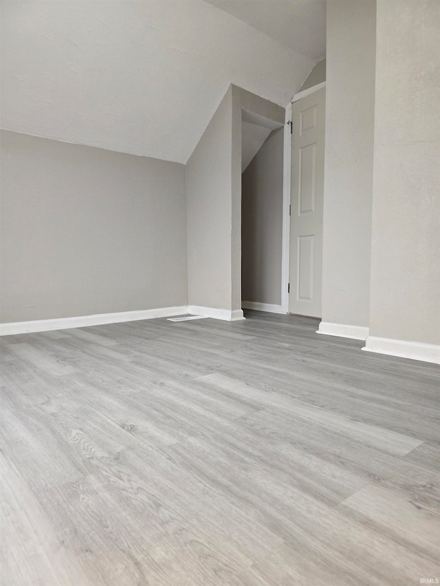 bonus room featuring vaulted ceiling and light wood-type flooring