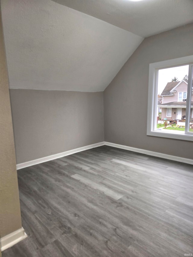 additional living space featuring dark hardwood / wood-style flooring and vaulted ceiling