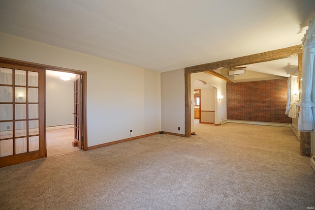 spare room featuring french doors, light colored carpet, and brick wall