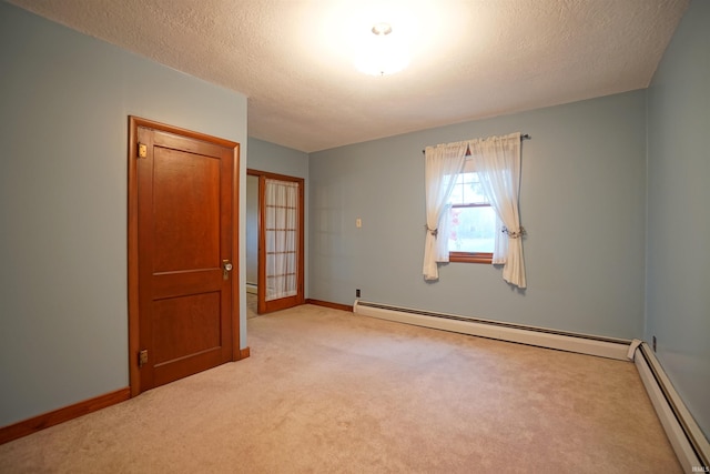 empty room with a textured ceiling, light colored carpet, baseboard heating, and french doors