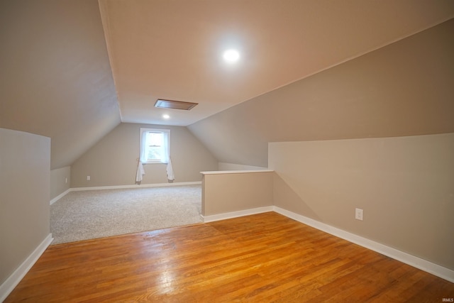 bonus room with vaulted ceiling and light wood-type flooring