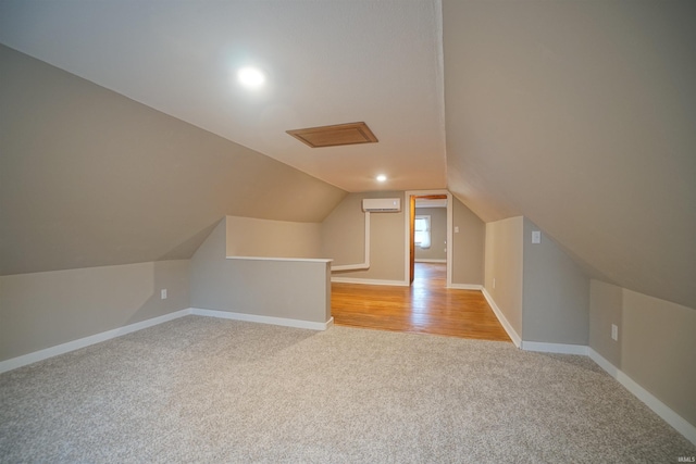 bonus room featuring vaulted ceiling, light colored carpet, and an AC wall unit