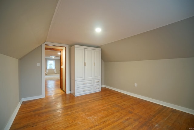 additional living space featuring light hardwood / wood-style flooring and vaulted ceiling