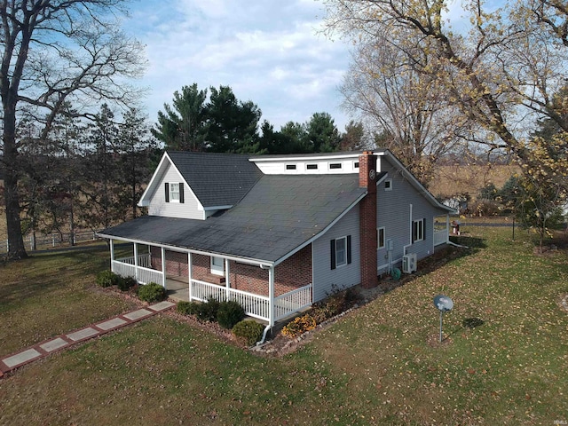 view of front facade with central AC unit, a porch, and a front lawn