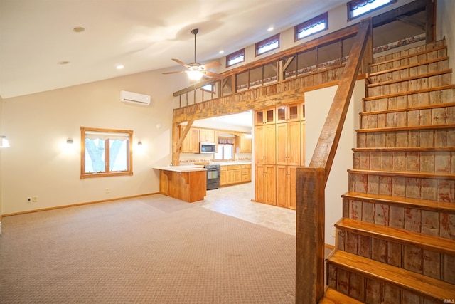 kitchen featuring light carpet, ceiling fan, appliances with stainless steel finishes, a wall mounted AC, and kitchen peninsula