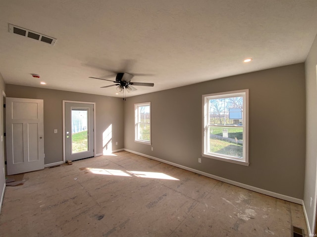 unfurnished room featuring ceiling fan and plenty of natural light