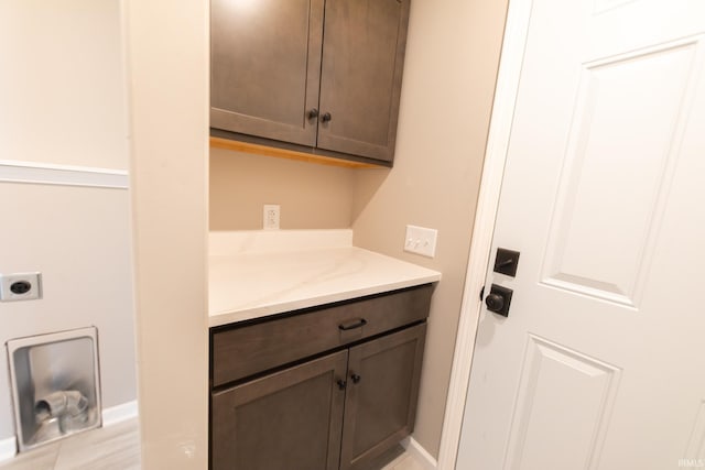 laundry area with electric dryer hookup and cabinets