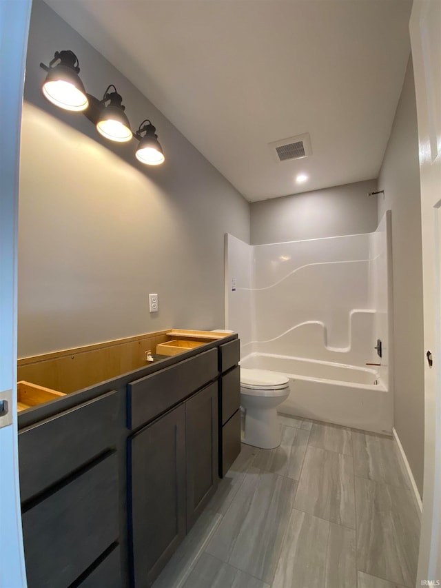 full bathroom featuring washtub / shower combination, vanity, and toilet