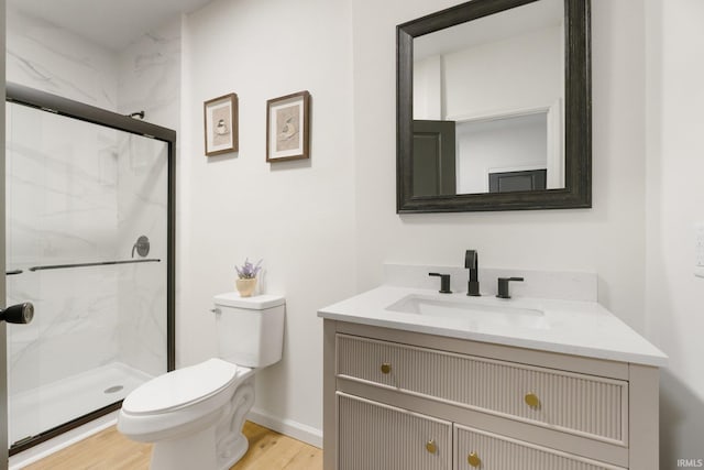 bathroom with hardwood / wood-style flooring, vanity, toilet, and a shower with door