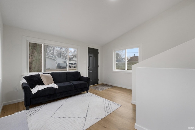 living room featuring vaulted ceiling and light hardwood / wood-style flooring