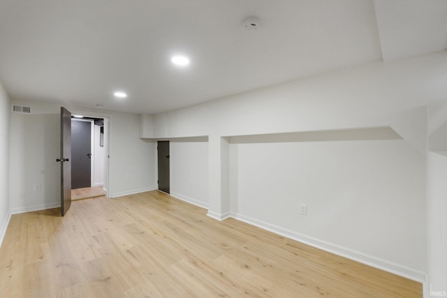 basement with light hardwood / wood-style flooring