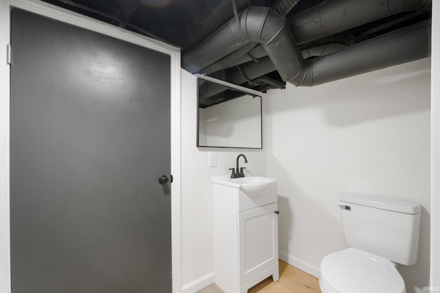 bathroom with hardwood / wood-style floors, vanity, and toilet