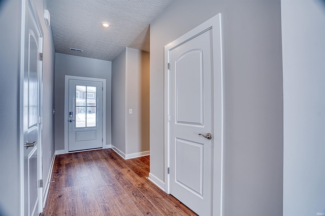 entryway with a textured ceiling and dark wood-type flooring