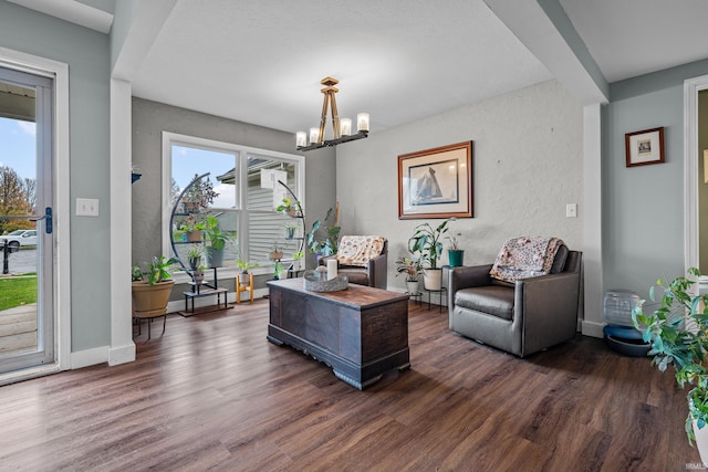 home office featuring baseboards, dark wood finished floors, a notable chandelier, and a textured wall