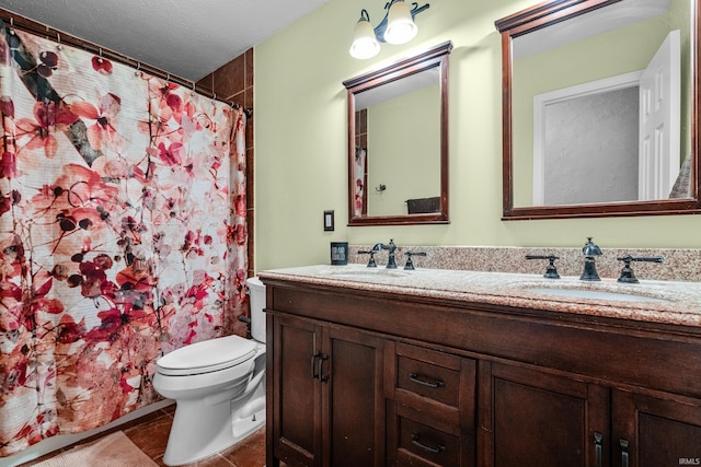 bathroom featuring tile patterned floors, a sink, toilet, and double vanity