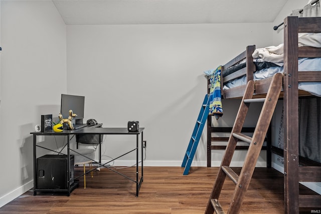 bedroom with baseboards and wood finished floors