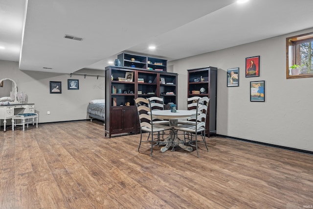 dining room with wood finished floors, visible vents, and baseboards