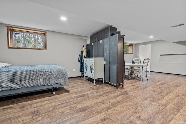 bedroom with multiple windows, wood finished floors, visible vents, and recessed lighting