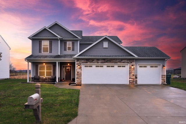 craftsman inspired home featuring a garage and a yard