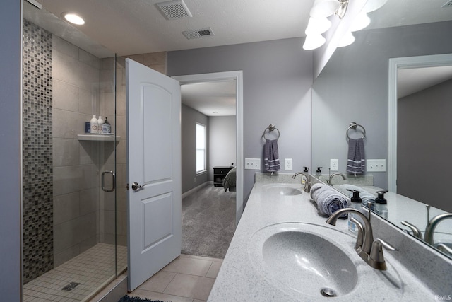 bathroom with tile patterned floors, vanity, and a shower with door