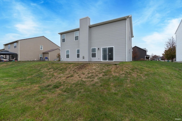 rear view of house featuring a lawn and a gazebo