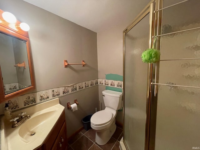 bathroom with tile patterned floors, vanity, a shower with shower door, and toilet