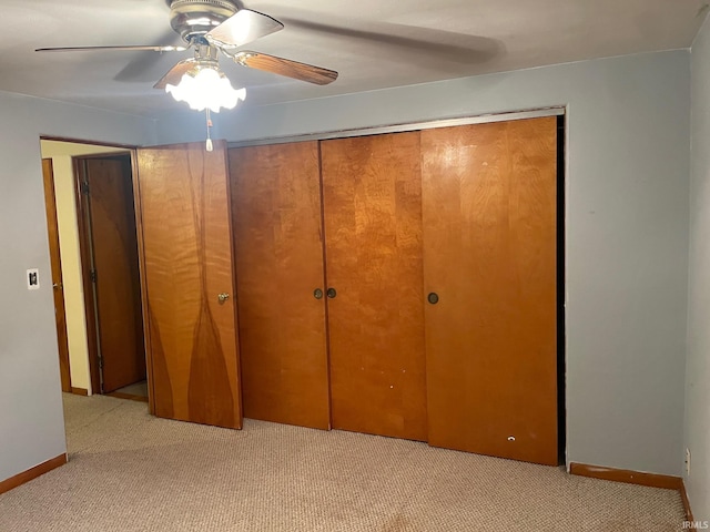 unfurnished bedroom with ceiling fan, a closet, and light colored carpet