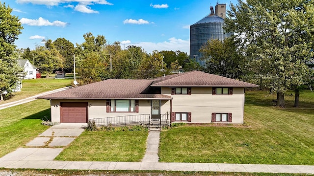 tri-level home with a front lawn, covered porch, and a garage