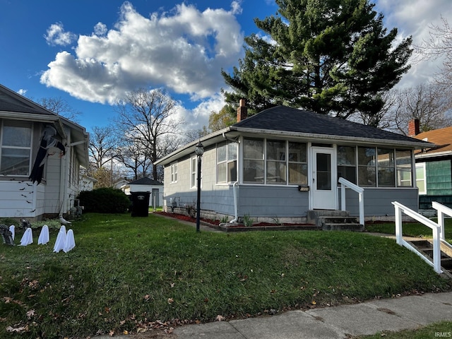 view of front of home with a front lawn and a sunroom