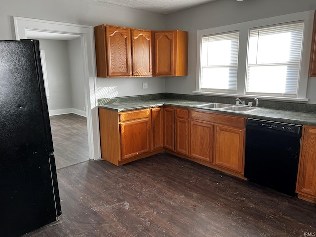 kitchen with a textured ceiling, sink, dark hardwood / wood-style floors, and black appliances